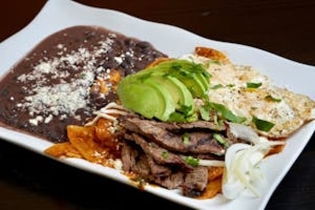 Red Chilaquiles with Grilled Steak, Eggs, & Beans.