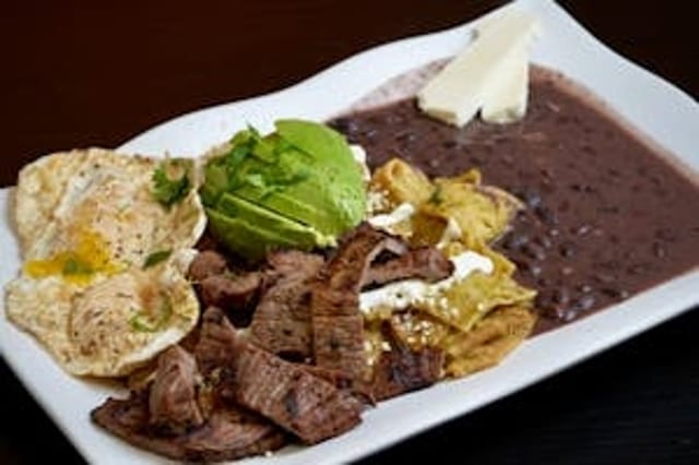 Green Chilaquiles with Grilled Steak, Eggs, & Beans.